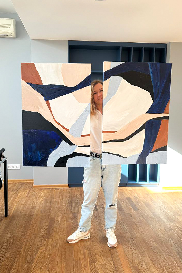 The artist holding the two panels of a diptych